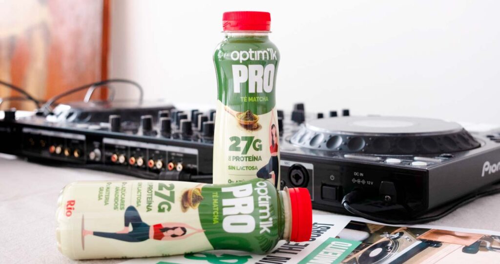 Batidos de proteínas té matcha optimilk encima de una mesa junto a una mesa de sonido de DJ