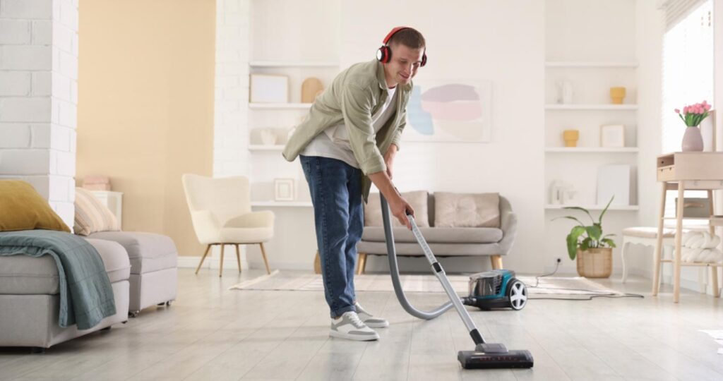 Persona limpiando el salón de su casa con una aspiradora aumentando su NEAT